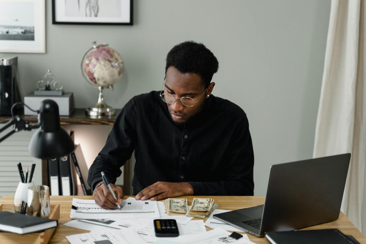 man writing at desk, annual accounts